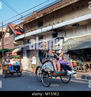 Risciò ciclo muovendosi lungo Pajeksan Street (Jalan Pajeksan). Yogyakarta, Java, Indonesia. Foto Stock