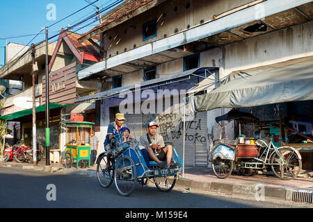 Cycle rickshaw muovendosi lungo Pajeksan Street (Jalan Pajeksan). Yogyakarta, Java, Indonesia. Foto Stock