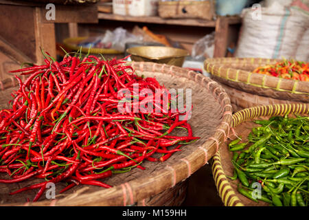 Cesti con rosso e peperoncini verdi per la vendita al mercato Beringharjo (Pasar Beringharjo). Yogyakarta, Java, Indonesia. Foto Stock