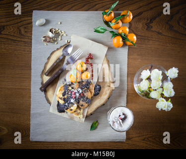 Bel piatto per la colazione sul vassoio in legno Frittelle e semifreddo con frutti decorate con condimenti sul tavolo. Pronto a mangiare. Close-up Foto Stock