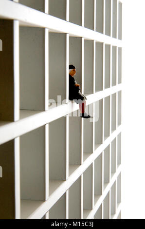 Figurina di una vecchia donna seduta su un ripiano Foto Stock