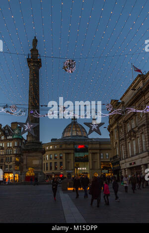 Newcastle, Inghilterra - Dicembre 31, 2017: persone intorno Grey's Monument sul Natale decorato Grey Street a Newcastle al crepuscolo della sera della vigilia di Capodanno Foto Stock