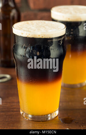 Irish layered nero e marrone con birra lager e Stought Foto Stock