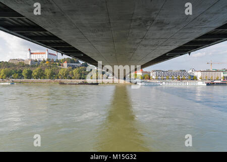 Vista di un castello medievale in Bratislava da sotto il ponte attraverso il fiume Danubio, Slovacchia. Foto Stock