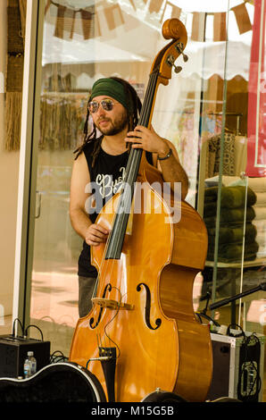 Uomo con dreadlocks strimpellamento sul suo violoncello a Tamworth Australia Country Music Festival 2018. Un membro di Andrew cugini Band. Foto Stock