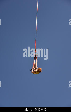 Bunovo, Bulgaria - 20 agosto 2017: ragazza giovane bungee jumper appeso a una fune. Giornata estiva con cielo blu Foto Stock