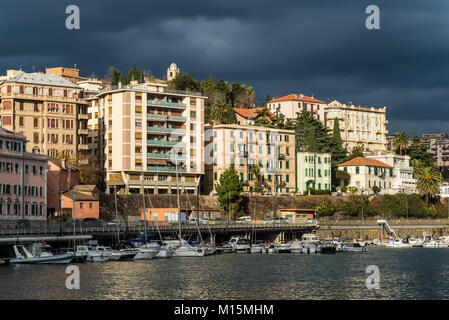 Savona, Italia - 2 Dicembre 2016: vista delle case residenziali nel sole contro lo sfondo di thunderclouds prima della tempesta in ligure del s Foto Stock