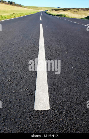 Un asfalto grigio vicolo del paese con forti linee bianche nel medio e basso punto di vista rende la strada e linee bianche grande in primo piano che conduce a Foto Stock