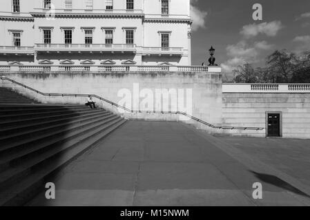 Londra, il Duca di York gradini che portano dal Mall a Waterloo Place tra Carlton House terrazze. L uomo si siede tranquillamente in appoggio sul suo proprio seduti sulla fase Foto Stock