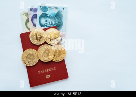 Fatture su supporto cartaceo la Cina in un passaporto rosso su sfondo bianco con la moneta cinese yuan, monete d'oro bitcoin. Foto Stock