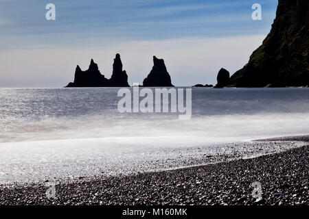 I picchi di roccia Reynisdrangar con surf sulla spiaggia vicino a Vík í Myrdal,a sud dell'Islanda,l'Islanda Foto Stock