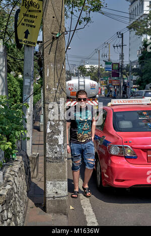 Thailandia street con pavimentazione bloccato da un alimentatore di energia elettrica post costringendo i pedoni nella strada trafficata e una situazione pericolosa dal traffico in senso contrario. Foto Stock