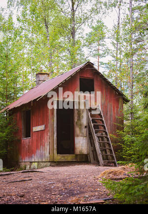 Abbandonato red cottage nei boschi. Foto Stock