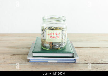Le monete in un barattolo di vetro con College Fund etichetta e libri. Risparmio di denaro, istruzione o college fund, il concetto di pianificazione, copia dello spazio. Foto Stock