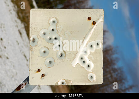 Un raggruppamento di fori di proiettile in metallo a forma di 'passante posto' cartello stradale in Scozia Foto Stock