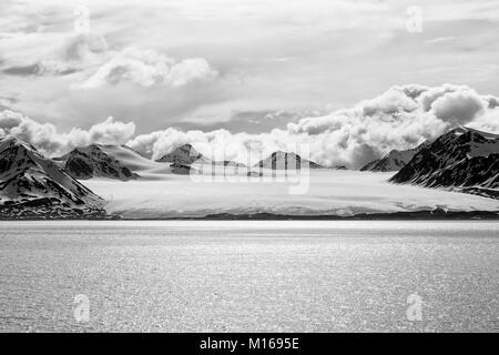 Mare baia con un ghiacciaio e le montagne sullo sfondo delle Svalbard Spitsbergen, Norvegia Foto Stock