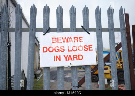 Attenzione cani allentato nel segno del cantiere sulla ringhiera di metallo per la sicurezza Foto Stock
