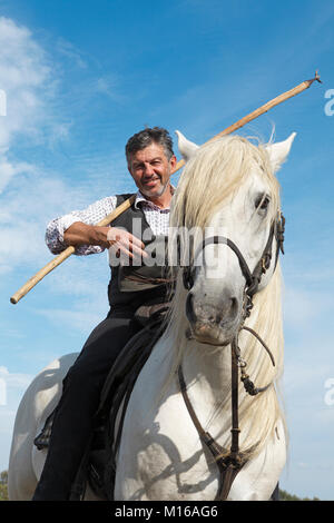 Gardian o tradizionali bull herder in tipici abiti da lavoro su un cavallo Camargue, Le Grau-du-Roi, Camargue, Francia Foto Stock