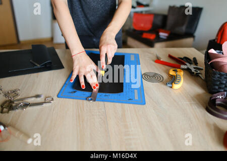 Slow motion ragazza prepara la pelle per rendere la borsa. Foto Stock