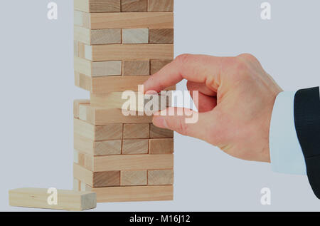 La torre da blocchi di legno e di mano d'uomo prendere un blocco Foto Stock