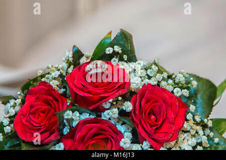 Gli anelli sul red bouquet di rose al matrimonio . Anello di nozze in rosa ti sposerà me Foto Stock