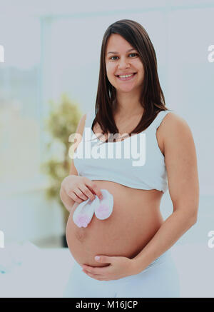 Donna incinta dimostra il futuro del bambino calze Foto Stock