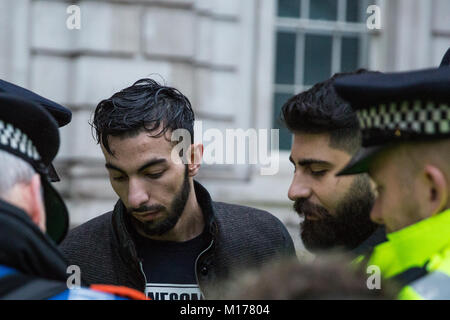 Londra, Regno Unito. Il 27 gennaio, 2018. Gli ufficiali di polizia prendere i dettagli di indirizzo da un uomo arrestato il sospetto di un reato ai sensi della sezione 13 della legge sul terrorismo dopo aver volato una bandiera vietata durante una manifestazione di protesta da parte dei membri della comunità curda di fronte a Downing Street contro la Turchia offensiva militare in ed intorno a curda Afrin controllato in Siria e contro una dichiarazione fatta dal Segretario degli esteri britannico Boris Johnson a sostegno della Turchia. Credito: Mark Kerrison/Alamy Live News Foto Stock