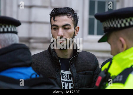 Londra, Regno Unito. Il 27 gennaio, 2018. Gli ufficiali di polizia prendere i dettagli di indirizzo da un uomo arrestato il sospetto di un reato ai sensi della sezione 13 della legge sul terrorismo dopo aver volato una bandiera vietata durante una manifestazione di protesta da parte dei membri della comunità curda di fronte a Downing Street contro la Turchia offensiva militare in ed intorno a curda Afrin controllato in Siria e contro una dichiarazione fatta dal Segretario degli esteri britannico Boris Johnson a sostegno della Turchia. Credito: Mark Kerrison/Alamy Live News Foto Stock