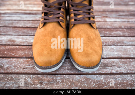 Coppia di mens tan stivali in pelle scamosciata su un pavimento di legno. Foto Stock