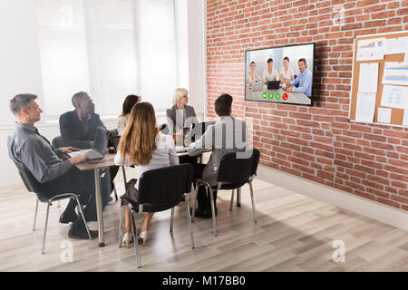Un gruppo di imprenditori aventi Video conferenza nella sala riunioni Foto Stock