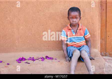 Ragazzo africano nella parte anteriore della casa di villaggio, Botswana Foto Stock