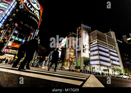 Tokyo, Giappone. Pedoni di attraversare la strada nel cuore del quartiere di Ginza a Tokyo. Ginza attraversando la notte. Moto sfocata. Foto Stock