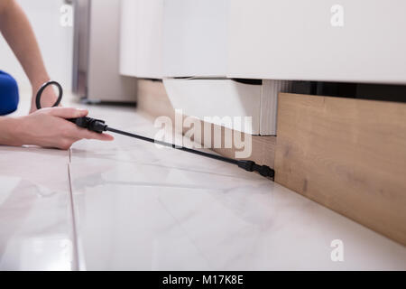 Close-up di un controllo di peste del lavoratore di spruzzatura a mano sui pesticidi Cabinet in legno Foto Stock