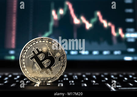 Coniate Bitcoin token cryptocurrency coin close up hero macro con mercato di negoziazione schermo in background. Foto Stock