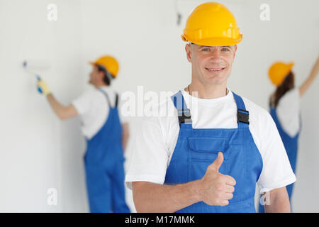 Workman dà pollice in alto nella parte anteriore dei due pittori Foto Stock