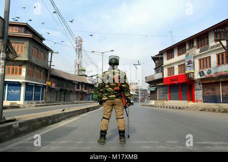 Srinagar, nello spazio. 28 gen, 2018. Un poliziotto indiano si erge alert durante il coprifuoco a Srinagar, Indiano Kashmir amministrato.la gente musulmana in Kashmir è il tentativo di ospitare manifestazioni domenica contro l uccisione di due civili dalle forze governative nel sud del Kashmir Shopian district, il governo ha risposto imponendo coprifuoco a cercato di rivendicazione della situazione. Credito: Saqib Majeed/SOPA/ZUMA filo/Alamy Live News Foto Stock