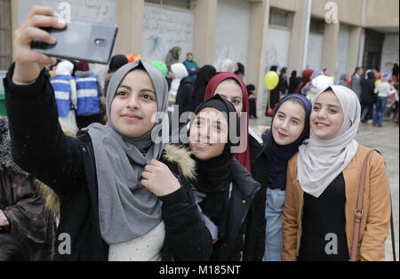 Amman, Giordania. 28 gen, 2018. Gli studenti hanno un selfie durante una visita del Presidente tedesco Frank-Walter Steinmeier e sua moglie Elke Buedenbender Al Quds School di Amman, Giordania, 28 gennaio 2018. Steinmeier è su un viaggio di 5 giorni per la Giordania e il Libano. Credito: Jörg Carstensen/dpa/Alamy Live News Foto Stock