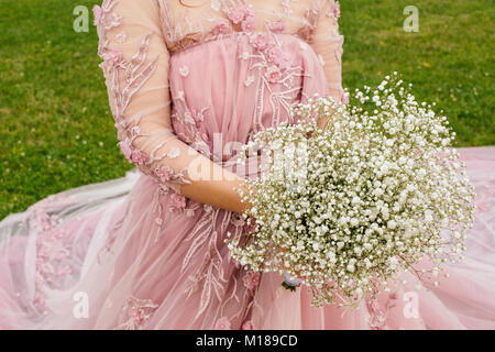 La sposa un abito rosa è in possesso di un bouquet di gypsophila Foto Stock