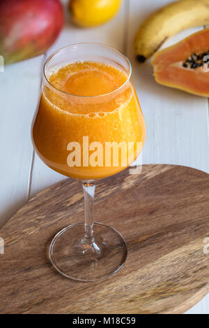 Frullato fresco succo da una papaia frutti, banana, mango e limone in vetro. Foto Stock