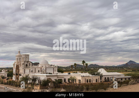 Tucson, Arizona, Stati Uniti d'America - 9 Gennaio 2018: Il territorio e tutto il complesso storico di San Xavier del Bac missione sotto pesanti bassa grigio cloudscap pendenti Foto Stock