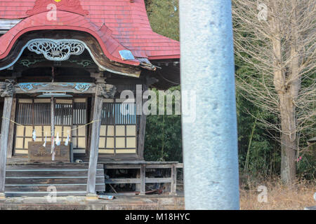 (16 gennaio, 2016 Namie, Fukushima, Giappone) un locale piccolo santuario inclinato su un lato e lasciati da soli a causa di terremoto 11 marzo 2011, Namie-città, Fukushima 2016. Nota: questo santuario fu distrutto dal terremoto su 11, Marzo 2011 ma non da Fukushima Daiich catastrofe nucleare. La ricostruzione della città Namie dalle conseguenze dello tsunami è stato il ritardo dovuto al suo status di zona di evacuazione tuttavia da 31, Marzo 2017 in poi, rimpatriati sono in grado di vivere in aree decontaminato in giù. Foto Stock