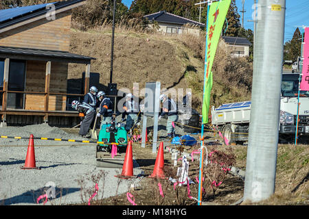 (16 gennaio, 2016 Namie, Fukushima, Giappone) la decontaminazione dei lavoratori fossero pulizia di terreni contaminati. La ricostruzione della città Namie dalle conseguenze dello tsunami è stato il ritardo dovuto al suo status di zona di evacuazione tuttavia da 31, Marzo 2017 in poi, rimpatriati sono in grado di vivere in aree decontaminato in giù. Foto Stock