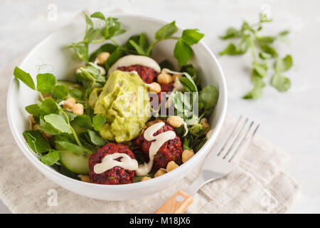 Di verdura verde insalata vegano con bietole polpette, guacamole e tahini medicazione. Una sana alimentazione vegetariana concetto. Foto Stock