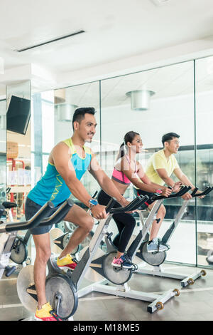 Bello e fiducioso giovane durante il gruppo classe di HIIT indo Foto Stock