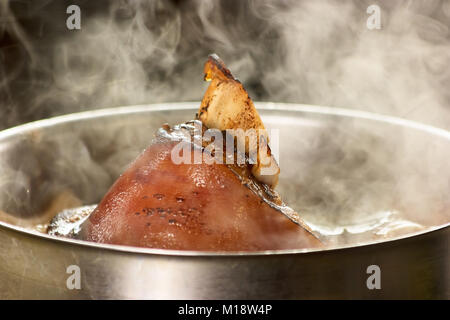 Arrosto di maiale con punto di ebollizione nel tegame. Foto Stock