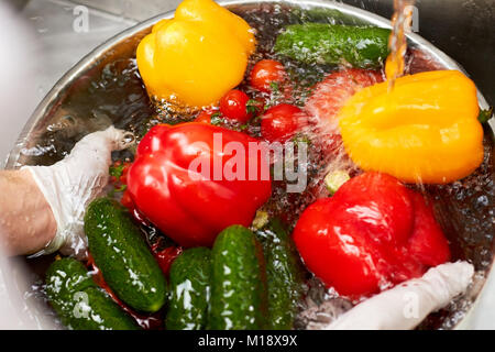 Acqua di rubinetto che cade su di verdure e schizzi. Foto Stock