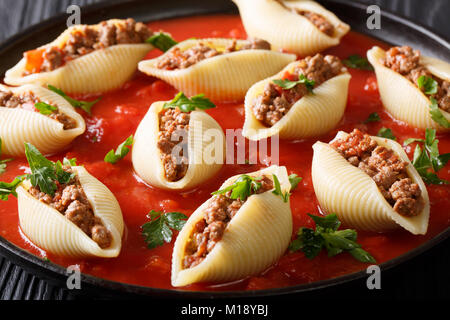 Guscio di pasta conchiglioni farcite con carne di manzo con salsa marinara close-up sulla piastra sulla tavola orizzontale. Foto Stock