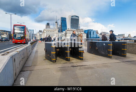 Anti-terrorismo anti-veicolo delle barriere di sicurezza o di difesa paracarri installato sul ponte di Londra nella città di Londra, nel Regno Unito e in vista dei grattacieli iconica Foto Stock