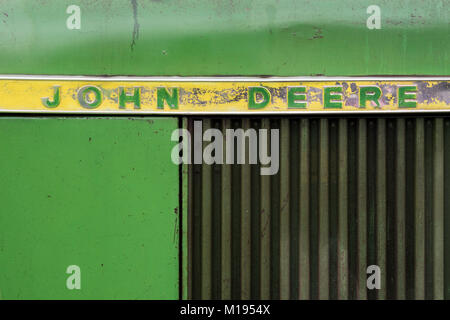 Vista laterale di dettaglio di un'annata trattore John Deere, sbiadito e usura della vernice verde con il giallo e il verde il badge. Foto Stock