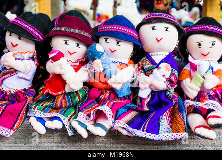 Fila di bambole in abiti tradizionali, Mercato di Otavalo, Ecuador Foto Stock